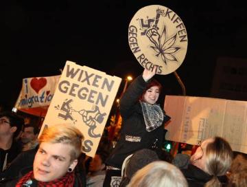 Demonstranten halten ein Plakat mit der Aufschrift "Kiffen gegen Rechts". Gegendemonstration unter dem Motto "Köln stellt sich quer". Kögida/Pegida ("Patriotische Europäer gegen die Islamisierung des Abendlandes") Demonstration in Köln am 5. Januar 2015.