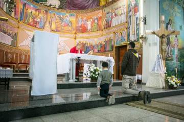 Junge Christen knien betend bei einem Gottesdienst in der katholischen Pfarrei "Heilige Familie" in Gaza.