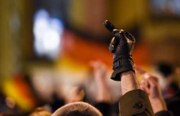 Ein Gegendemonstrant einer PEGIDA-Kundgebung am 9. Februar 2015 an der Hauptwache in Frankfurt am Main reckt seinen gestreckten Mittelfinger in die Höhe. Knapp 100 PEGIDA-Sympathisanten standen etwa 1000 Teilnehmern der Gegendemonstration gegenüber.